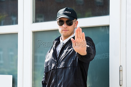 Male Security Guard Making Stop Sign With Hand - Stock Photo #15283139 